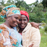 Two smiling ladies embrace with warm smiles