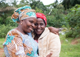 Two smiling ladies embrace with warm smiles