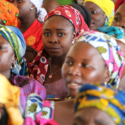 Closeup view of the faces of a group of women, all wearing colourful head coverings