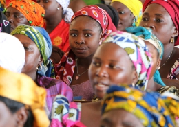 Closeup view of the faces of a group of women, all wearing colourful head coverings