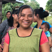 A woman smiling at the camera with a group of ladies behind her