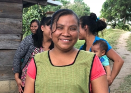 A woman smiling at the camera with a group of ladies behind her