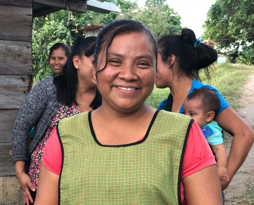 A woman smiling at the camera with a group of ladies behind her