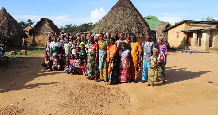 A group of people standing in a rural village, Guinea